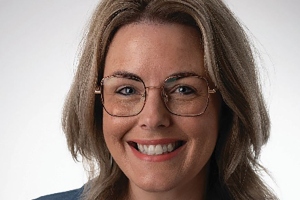 Lachende vrouw met blond haar en bril.