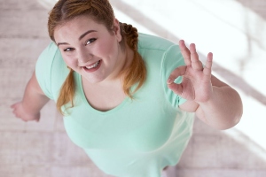 obesitas Obese vrouw maakt met haar vingers het ok teken.